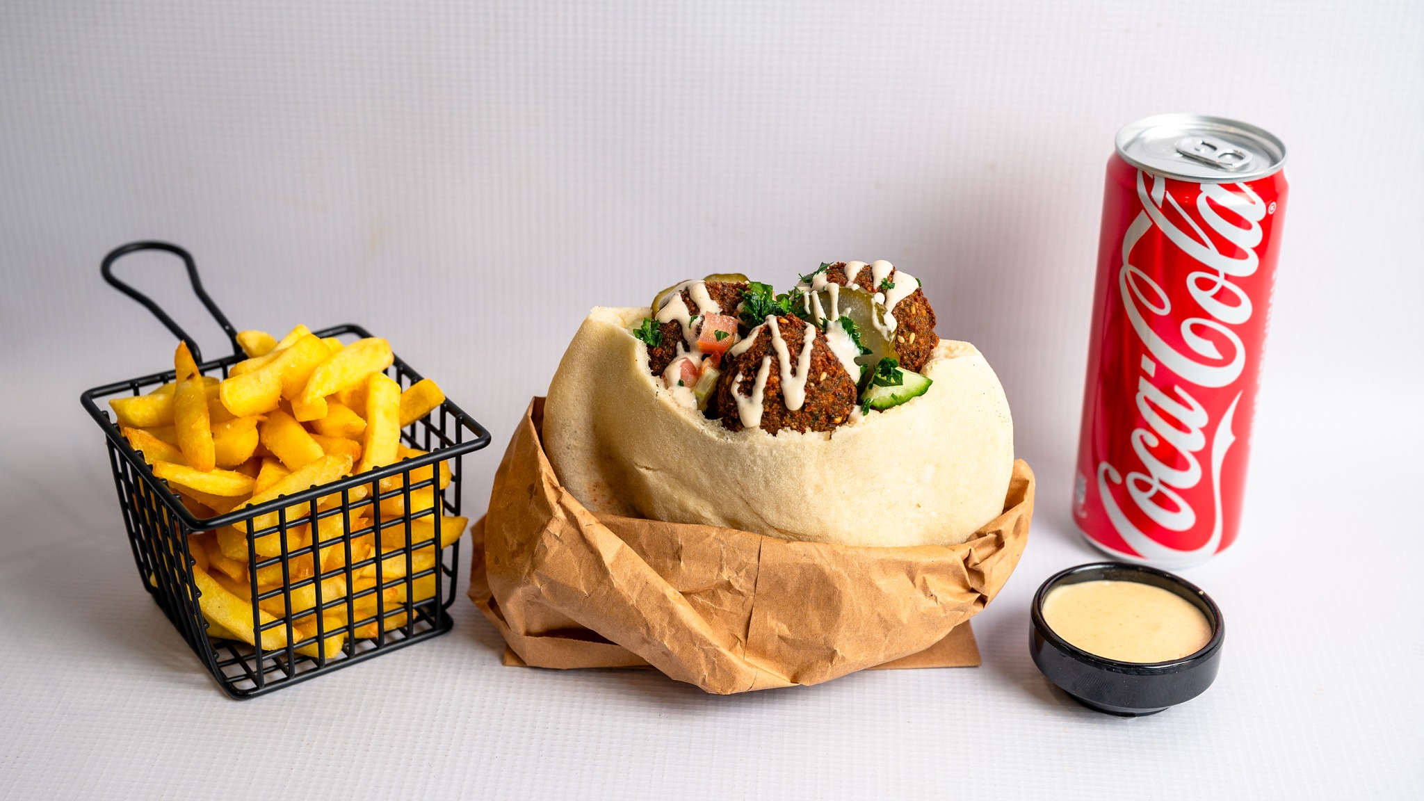 Falafel pita with fries, a soft drink and tahini