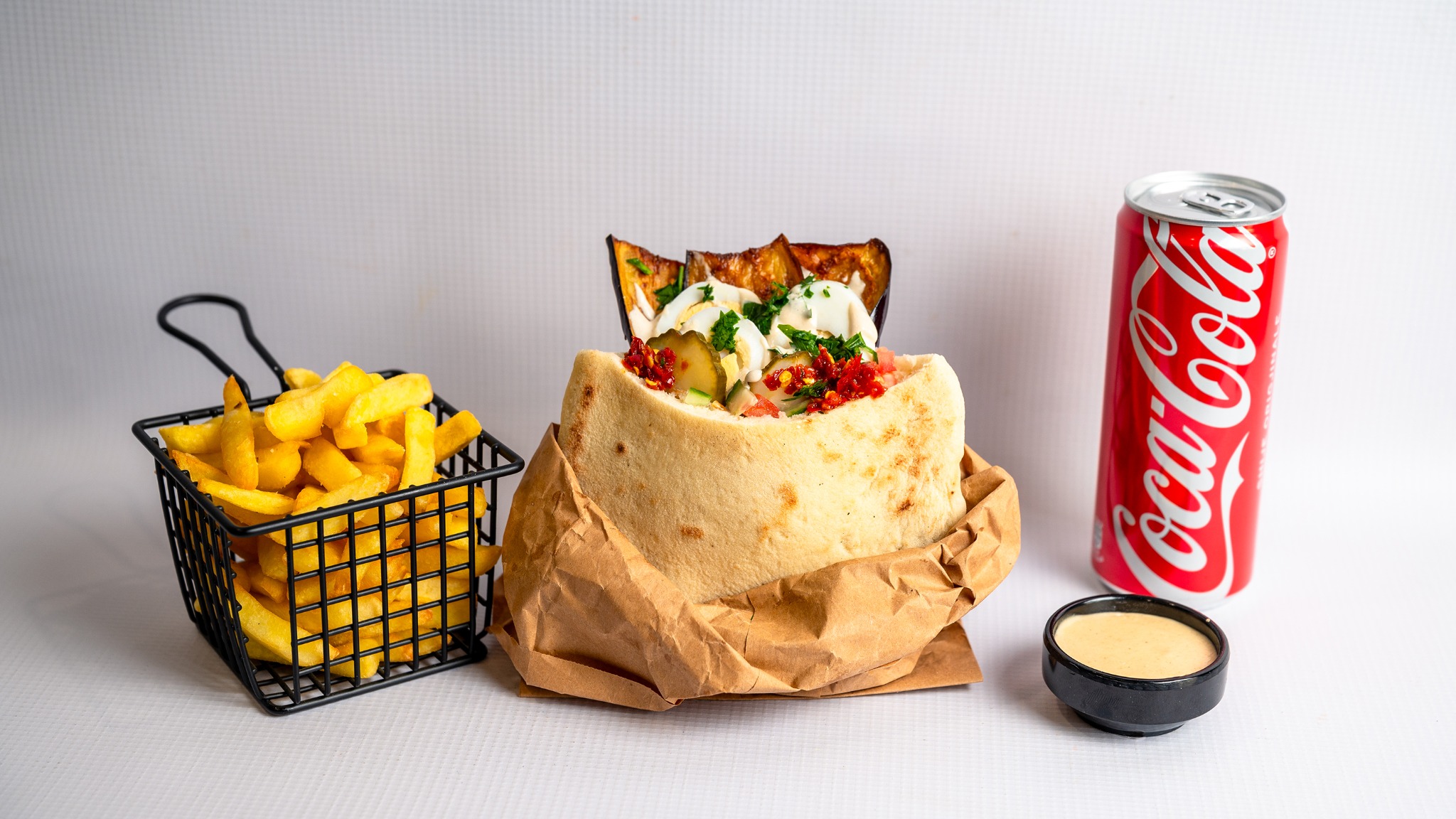 Sabich pita with fries, a soft drink and tahini